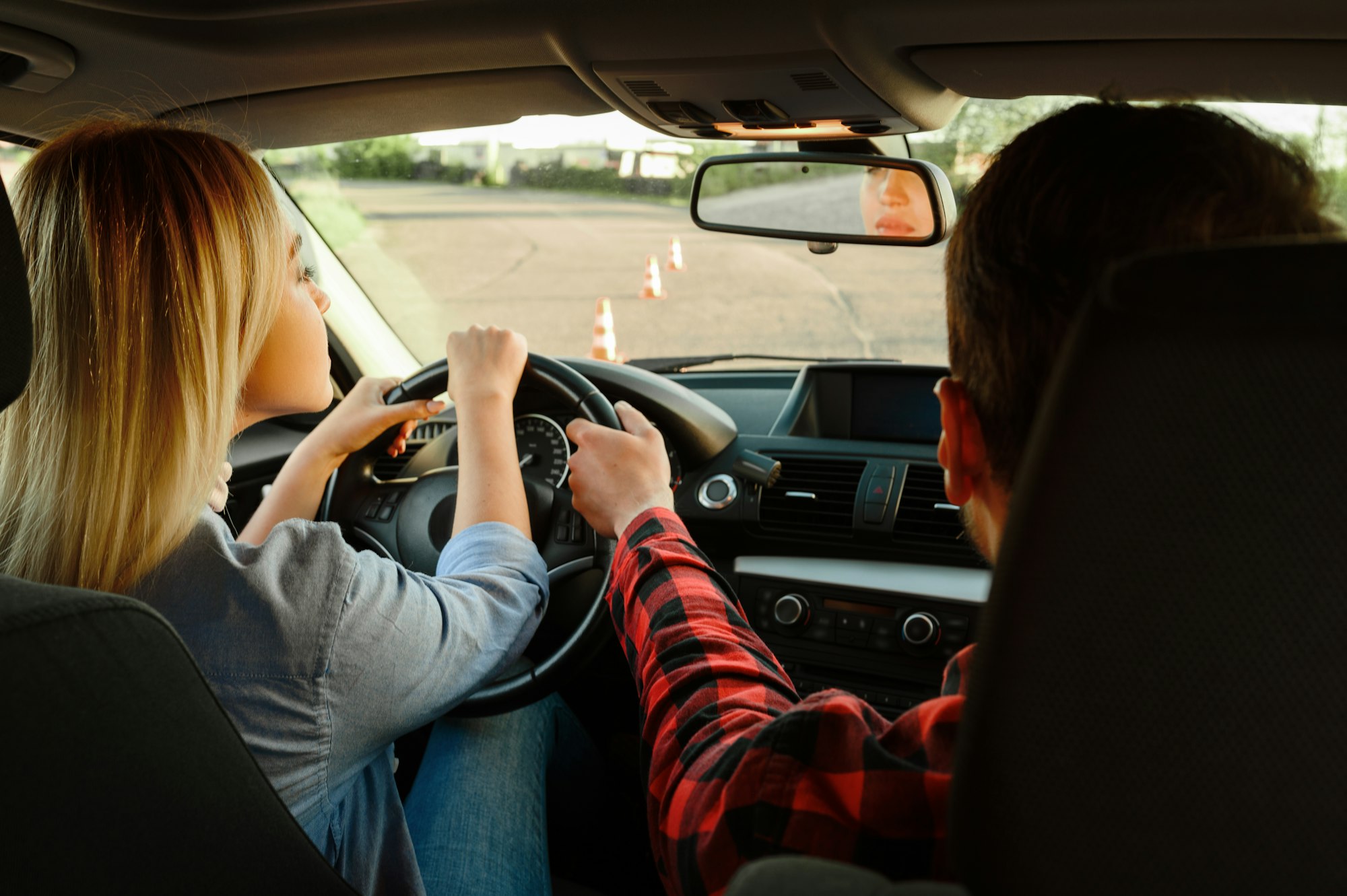 Instructor helps woman to drive the car